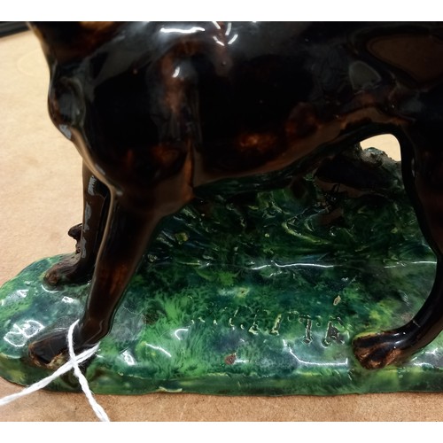 569 - Two French majolica greyhounds, 19th century, each modelled standing against a rough bocage support ... 