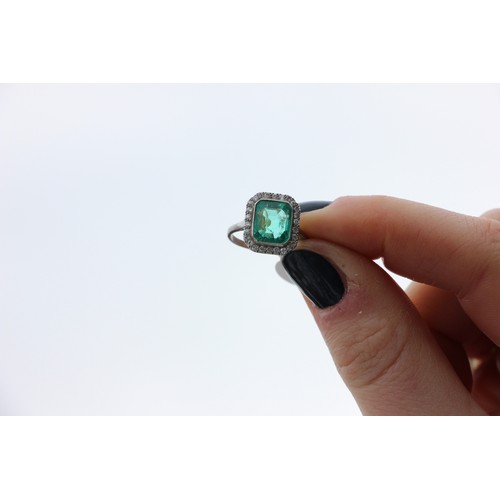 255 - An early 20th century untested emerald and diamond cluster ring, the central emerald cut emerald wit... 