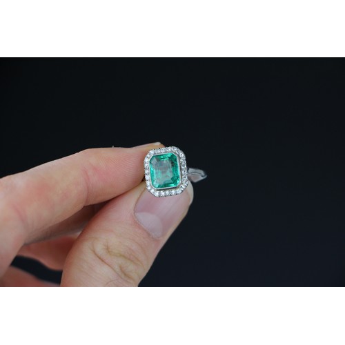 255 - An early 20th century untested emerald and diamond cluster ring, the central emerald cut emerald wit... 