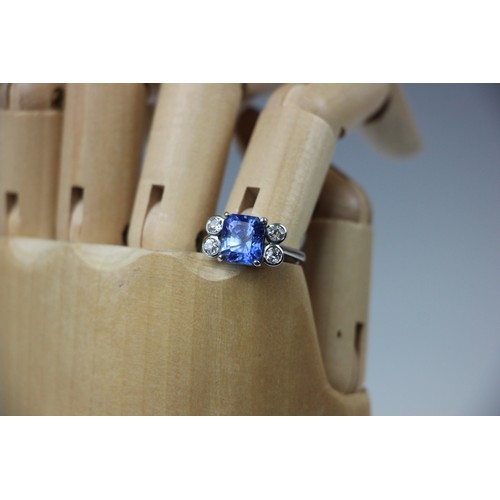 351 - A mid 20th century diamond and sapphire ring, the emerald cut sapphire claw set in white metal, with... 