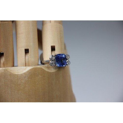 351 - A mid 20th century diamond and sapphire ring, the emerald cut sapphire claw set in white metal, with... 