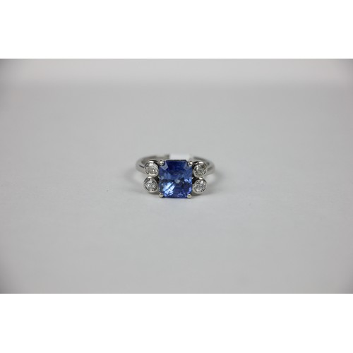 351 - A mid 20th century diamond and sapphire ring, the emerald cut sapphire claw set in white metal, with... 