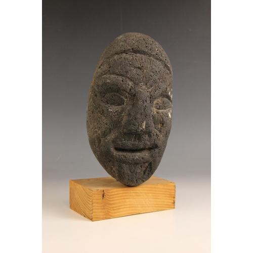 548 - Carved tribal head,  
Volcanic rock on wooden base,  
26cm high overall