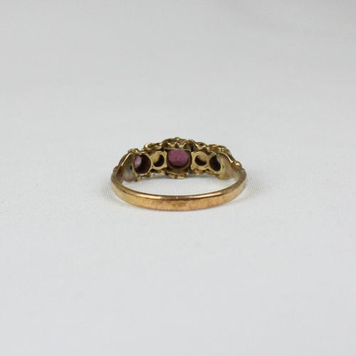 157 - An early 20th century 15ct ring, the central red stone set with opals to each side and further small... 