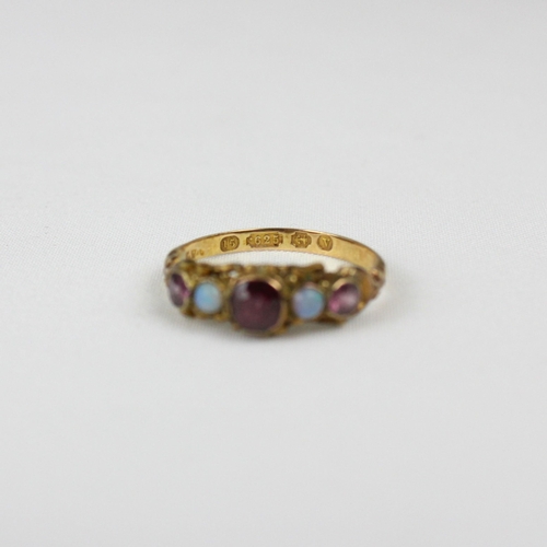 157 - An early 20th century 15ct ring, the central red stone set with opals to each side and further small... 