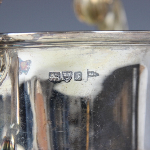 23 - An Edwardian silver twin handled trophy, Walker and Hall, Chester 1906, the scroll handles above pla... 