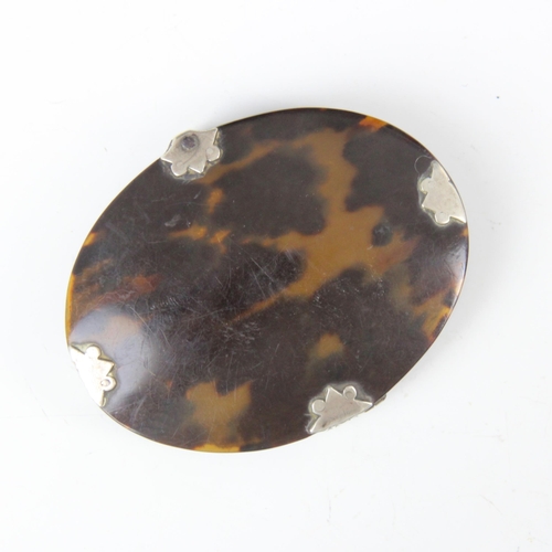 53 - An early 19th century tortoishell and white metal mounted magnifying glass, the oval shaped magnifyi... 