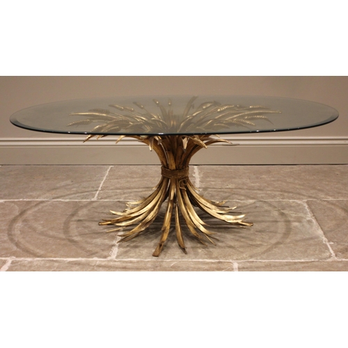 1003 - A Hollywood Regency gilt metal coffee/centre table, mid 20th century, the bevelled oval glass top up... 