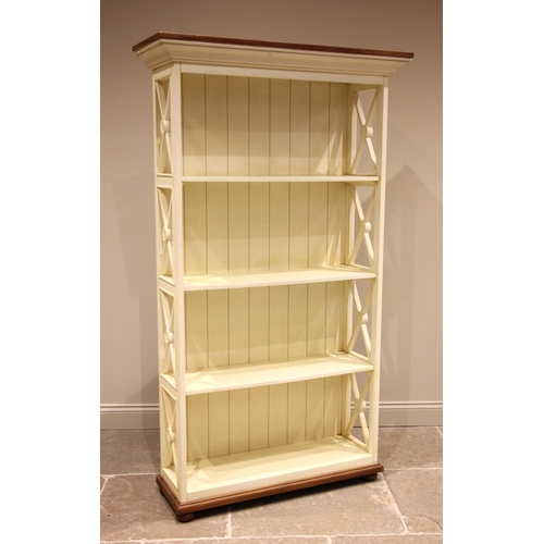 1005 - A contemporary painted open bookcase, the moulded cornice over four shelves enclosed by lattice rail... 