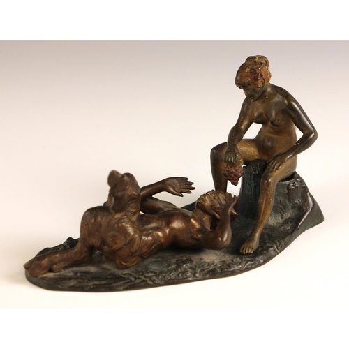 507 - A grand tour erotic bronze, 19th century, modelled as a recumbent faun being fed grapes by a concubi... 