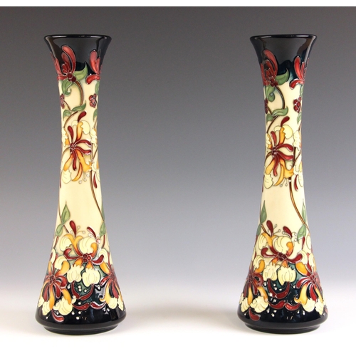 535 - A pair of Moorcroft vases in the 'Honeysuckle Haven' pattern by Rachel Bishop, of slender tapering f... 