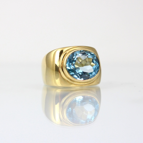 163 - A 'Fred' Paris 18ct yellow gold untested blue topaz dress ring, the oval mixed cut blue stone within... 