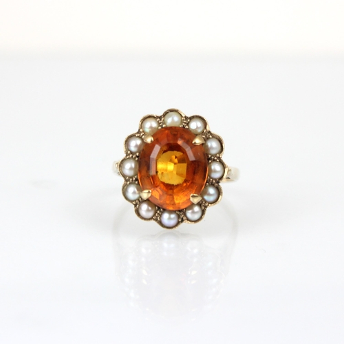 176 - An early 20th century citrine and pearl cluster ring, the central oval cut citrine within surround o... 