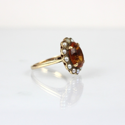 176 - An early 20th century citrine and pearl cluster ring, the central oval cut citrine within surround o... 