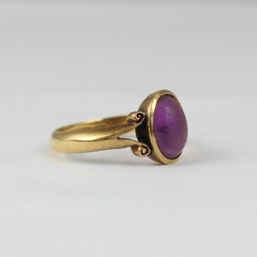 381 - An early 20th century 18ct yellow gold ring, the central 'amethyst' coloured cabochon in rub over mo... 