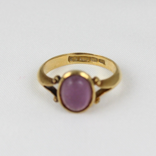 381 - An early 20th century 18ct yellow gold ring, the central 'amethyst' coloured cabochon in rub over mo... 