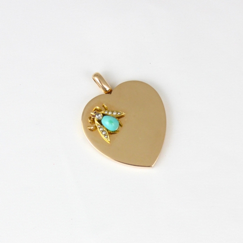 383 - An early 20th century yellow metal heart pendant/locket, the plain polished front with applied fly, ... 