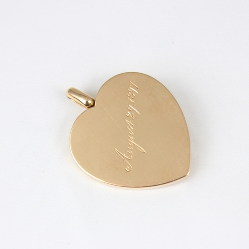 383 - An early 20th century yellow metal heart pendant/locket, the plain polished front with applied fly, ... 