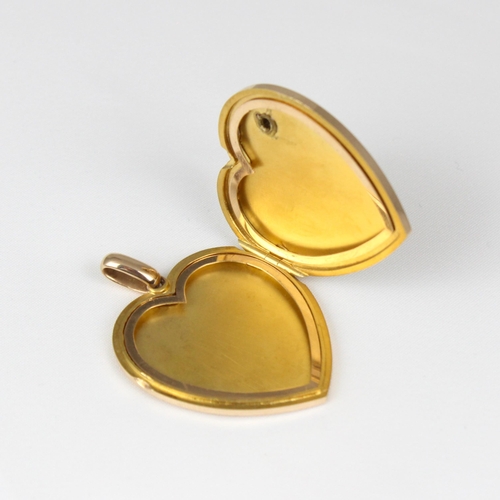 383 - An early 20th century yellow metal heart pendant/locket, the plain polished front with applied fly, ... 