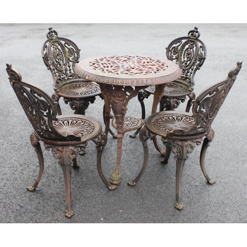 1010 - A set of four Victorian style cast iron patio/garden chairs, each with an interlaced openwork back r... 