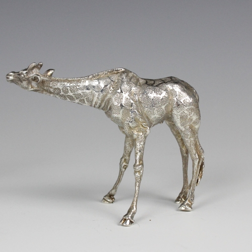 81 - A near pair of Patrick Mavros silver models of giraffes, each modelled standing with realistically c... 