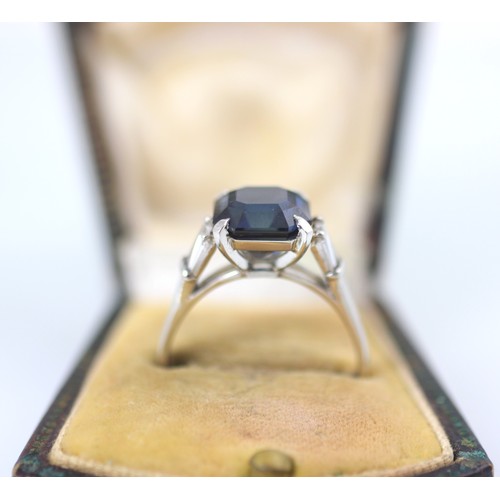 177 - An Art Deco style diamond and untested sapphire ring, the central emerald cut untested sapphire claw... 