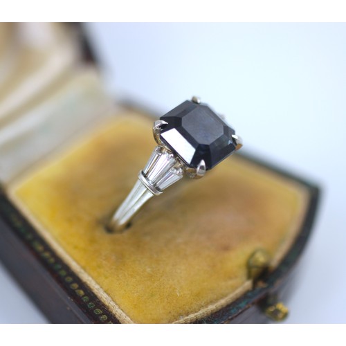 177 - An Art Deco style diamond and untested sapphire ring, the central emerald cut untested sapphire claw... 