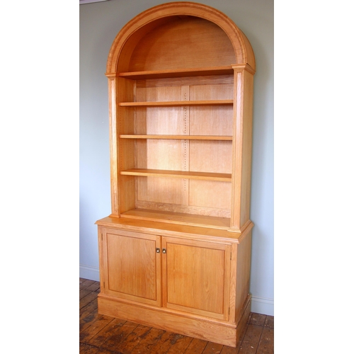 995 - A light oak architectural alcove bookcase, late 20th century, the domed pediment over three adjustab... 