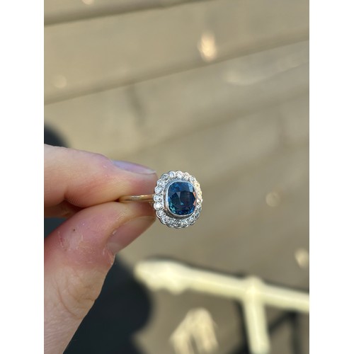 363 - An early/mid 20th century certified sapphire and diamond cluster ring, the mixed cut sapphire within... 