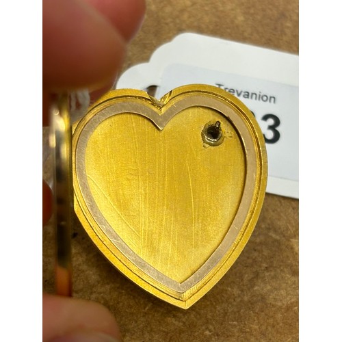 383 - An early 20th century yellow metal heart pendant/locket, the plain polished front with applied fly, ... 