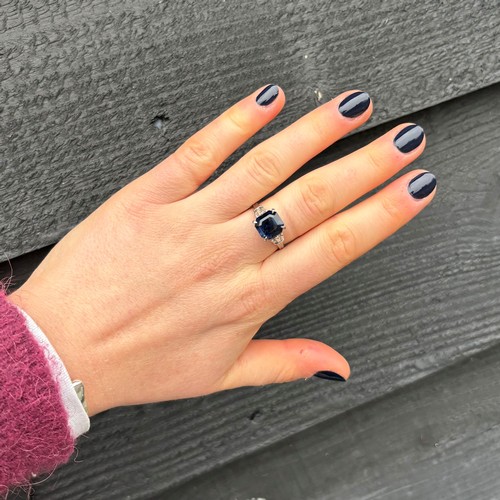 177 - An Art Deco style diamond and untested sapphire ring, the central emerald cut untested sapphire claw... 