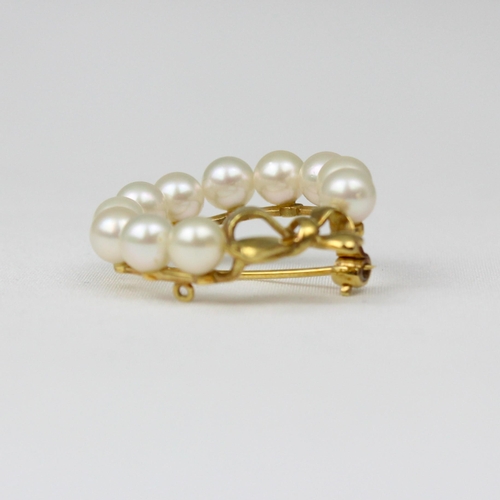 182 - A yellow metal cultured pearl brooch, possibly by Mikimoto, the eleven uniform cultured pearls set i... 