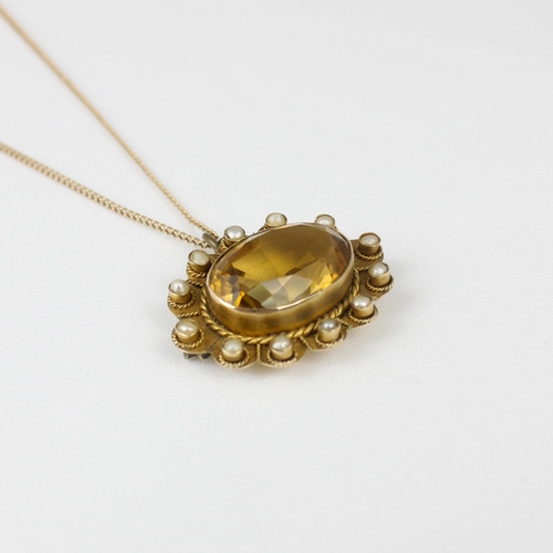 160 - An early 20th century citrine pendant/brooch, the oval cut citrine within scalloped edged mount, set... 