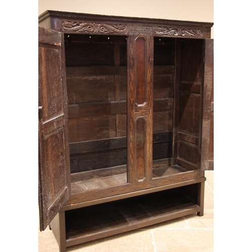 854 - An early 18th century Welsh carved oak livery cupboard, the carved frieze detailed with scrolling dr... 