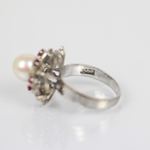 115 - A cultured pearl dress ring, the spherical pearl within stylised surround of red stones and white me... 