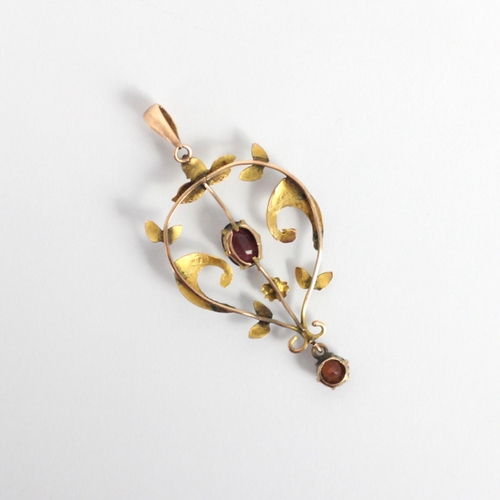 116 - An early 20th century garnet pendant, the oval cut garnet within sinuous yellow metal mount, suspend... 