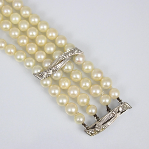 107A - A cultured pearl and diamond bracelet, the three white metal stylised bars set with six graduated di... 
