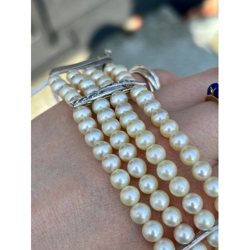 107A - A cultured pearl and diamond bracelet, the three white metal stylised bars set with six graduated di... 