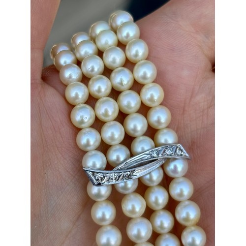 107A - A cultured pearl and diamond bracelet, the three white metal stylised bars set with six graduated di... 