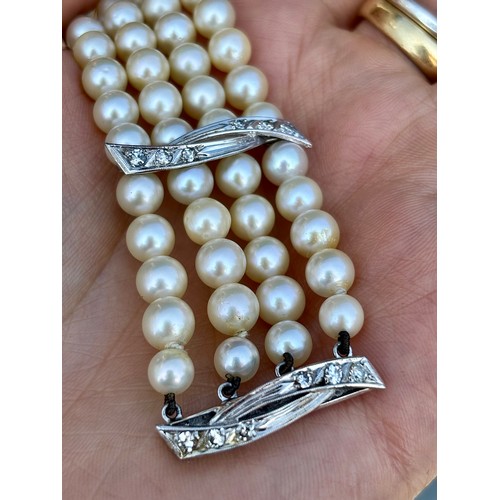 107A - A cultured pearl and diamond bracelet, the three white metal stylised bars set with six graduated di... 