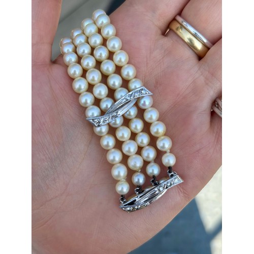 107A - A cultured pearl and diamond bracelet, the three white metal stylised bars set with six graduated di... 