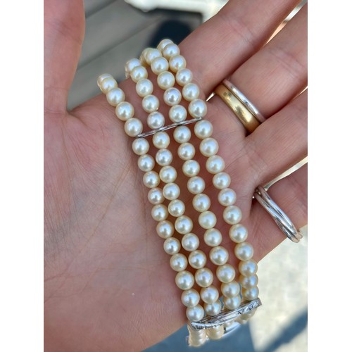 107A - A cultured pearl and diamond bracelet, the three white metal stylised bars set with six graduated di... 