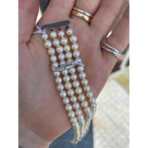 107A - A cultured pearl and diamond bracelet, the three white metal stylised bars set with six graduated di... 