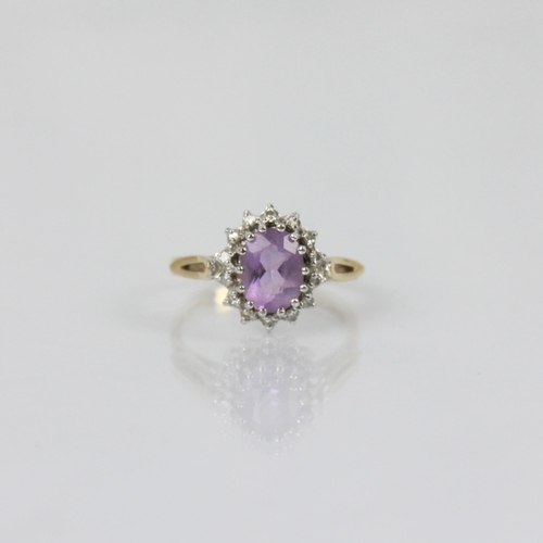 215 - An amethyst and diamond dress ring, the central oval amethyst within surround of diamonds in cluster... 