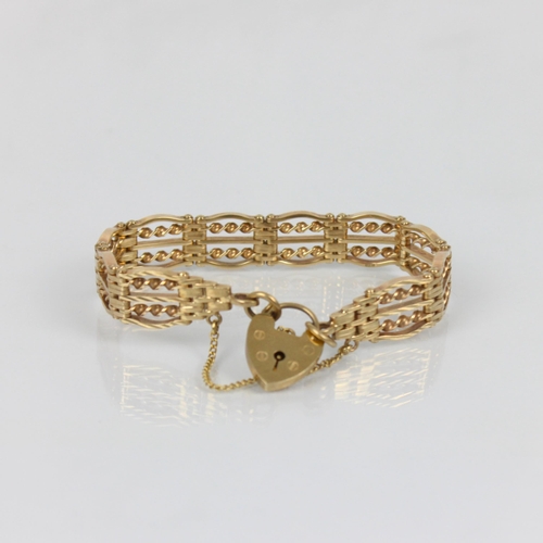 250 - A late 20th century 9ct gold stylised gate link bracelet, the hinged openwork oval links with rope t... 