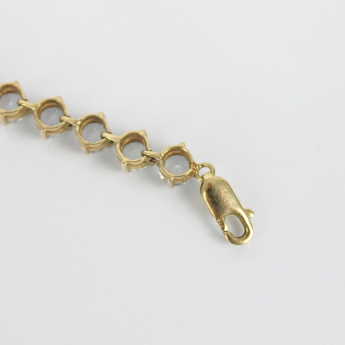 253 - A 9ct gold 'tennis' bracelet, the twenty seven pale blue stones set in claw setting edge, with lobst... 