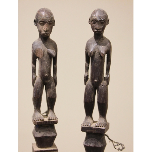 465 - A pair of Nigerian Yoruba staffs, each terminal carved with a standing figure above a square section... 