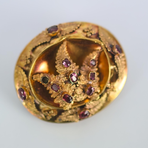 110 - An early/mid 19th century brooch, of oval form set with pink stones, possibly foil backed, within a ... 