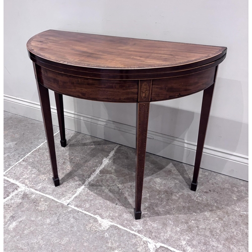 550 - A Regency mahogany and satinwood inlaid demi-lune tea table, the fold-over top raised on four legs o... 