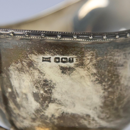 21 - A George V silver sauce boat, Walker & Hall, Sheffield 1933, the stylised beaded rim above plain pol... 